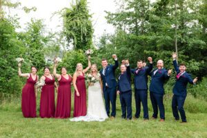 bride with bridesmaids in floor length raspberry gowns during backyard wedding in Monkland ON