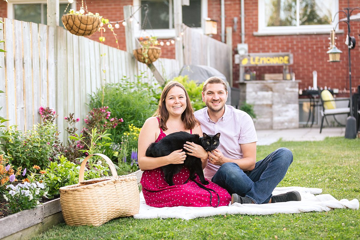 Couple hugging their pet cat during backyard portraits