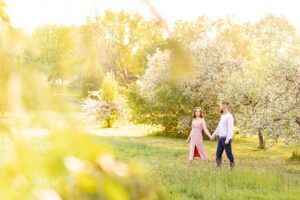 Ottawa Dominion Arboretum Engagement Photos - couple walking with spring blossoms