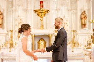 bride and groom exchange rings during wedding at St. Finnan Basilica in Alexandria, ON