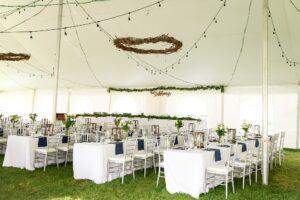 outdoor wedding tent with navy and greenery