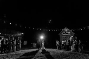Bride and groom give their speech under market lights with sprinklers