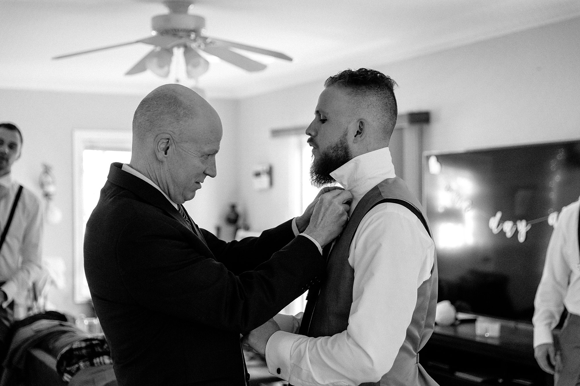 father helping groom put on bow tie
