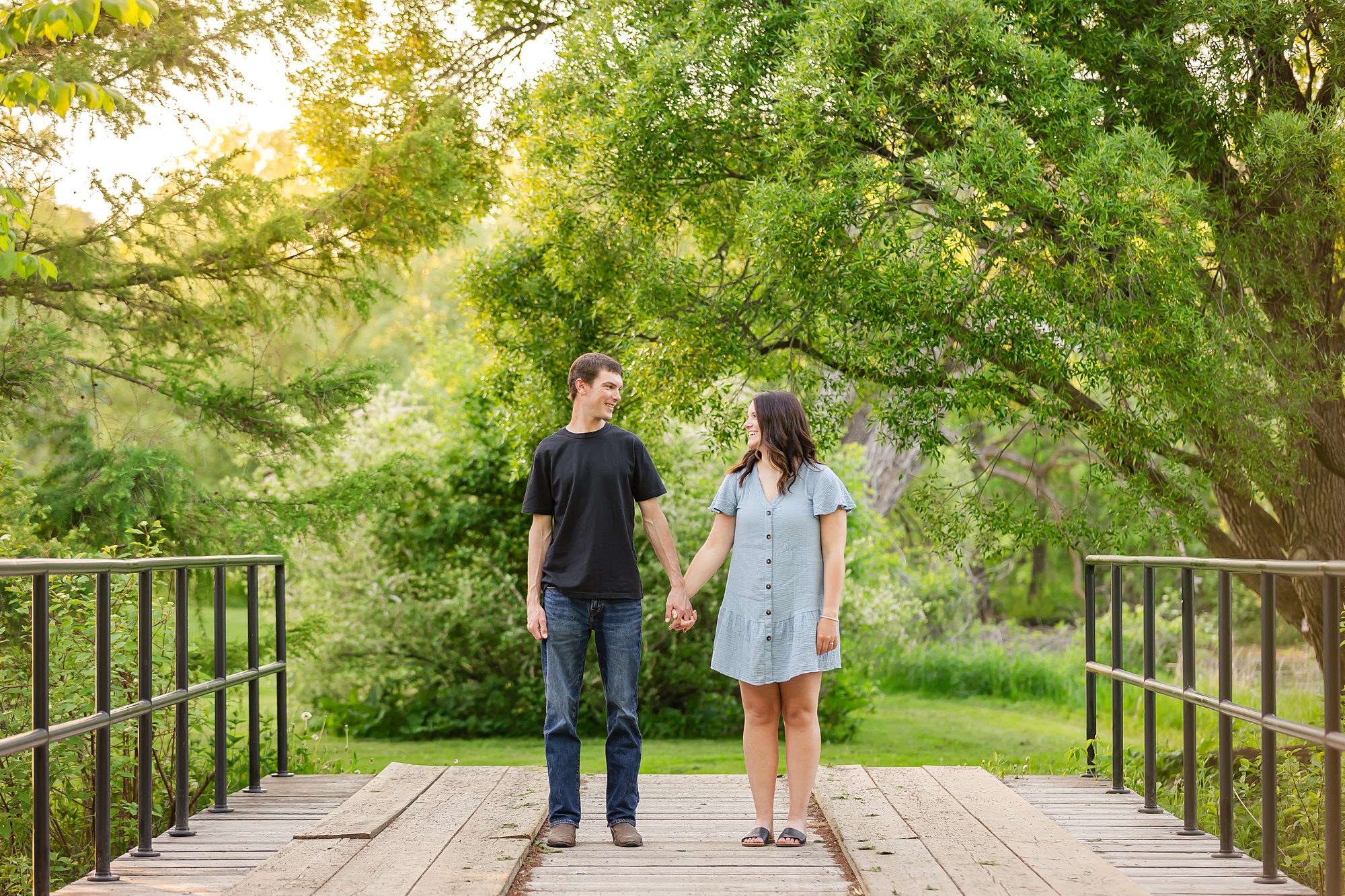 Couple standing on bridge during their Spring Engagement Photos at the Ottawa Arboretum