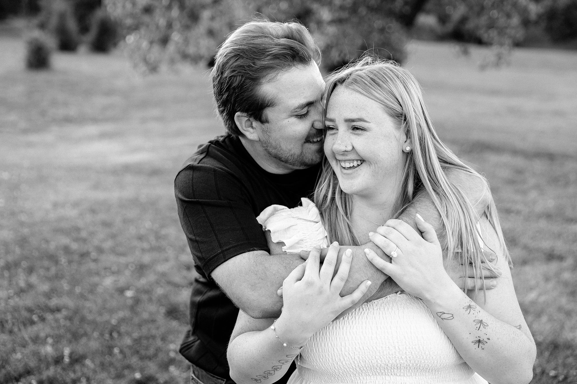 candid black and white photo of couple embracing for an engagement photo